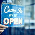 Barista hanging an open sign in restaurant